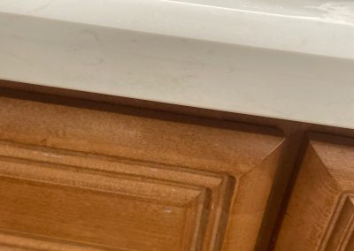 Close-up of a quartz bathroom vanity countertop front edge showing light surface marks after repair