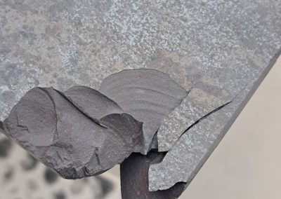 Close-up of broken countertop edge with missing stone before repair