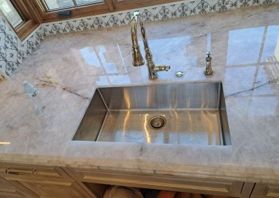 Undermount sink and faucet installation completed in stone countertop